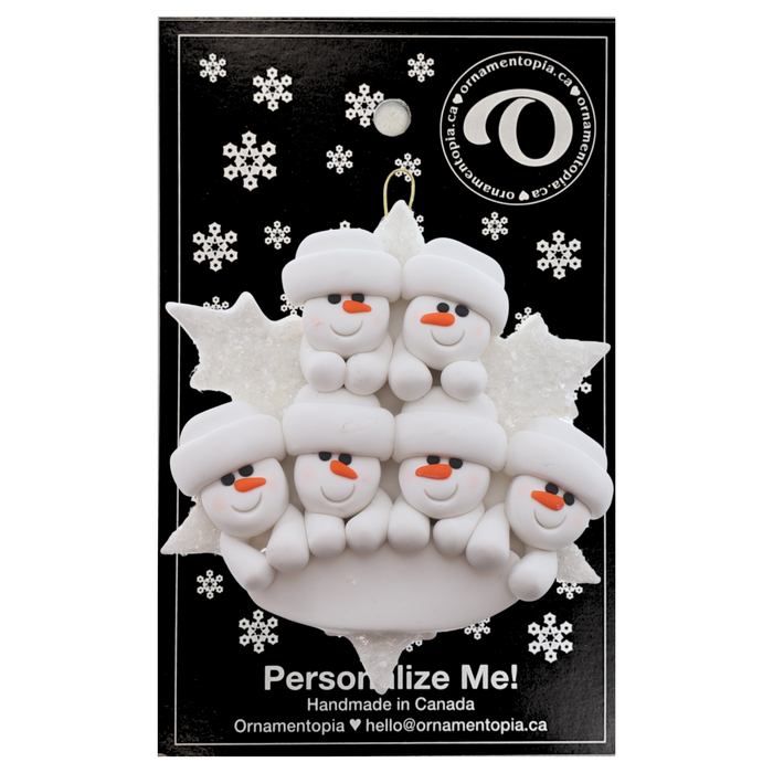 Family ornament with 6 white snowmen stacked on top of a glitter white snowflake, on display backing card.