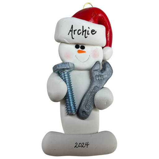 Ornament of white snowman in red hat holding a wrench and a screw, personalized with name.