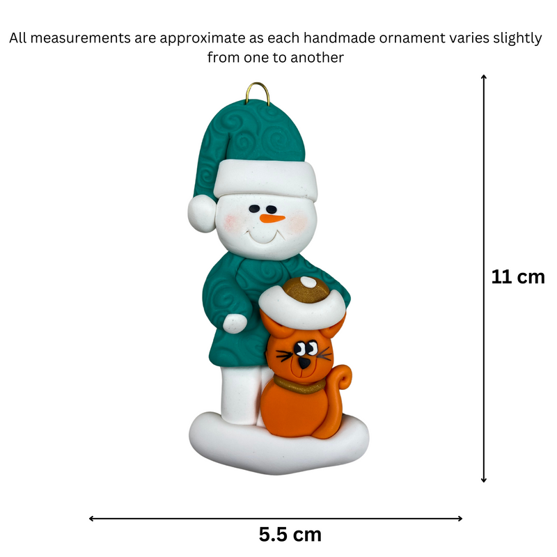 Ornament of snowman in a green shirt and hat with orange cat in Christmas hat, graphed to show size (5.5x11cm).