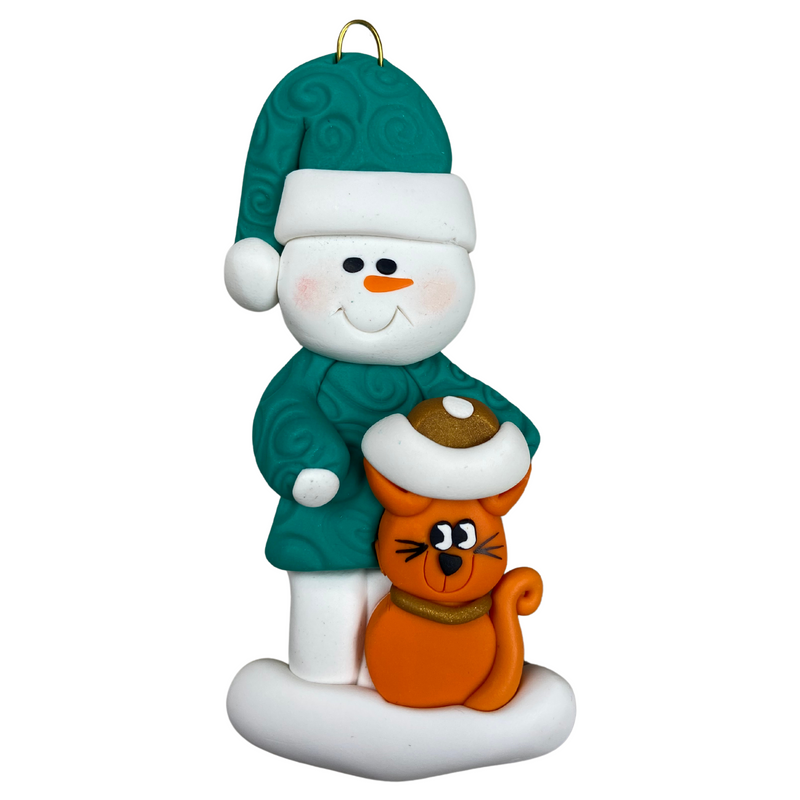 Ornament of snowman in a green shirt and hat with orange cat in Christmas hat.