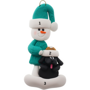 Ornament of snowman in green shirt and hat with black dog in Christmas hat, numbered 1-3 for personalization.