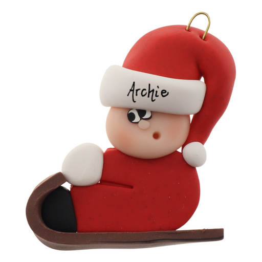 Small figure in red outfit and festive hat riding on brown toboggan ornament, personalized with name.